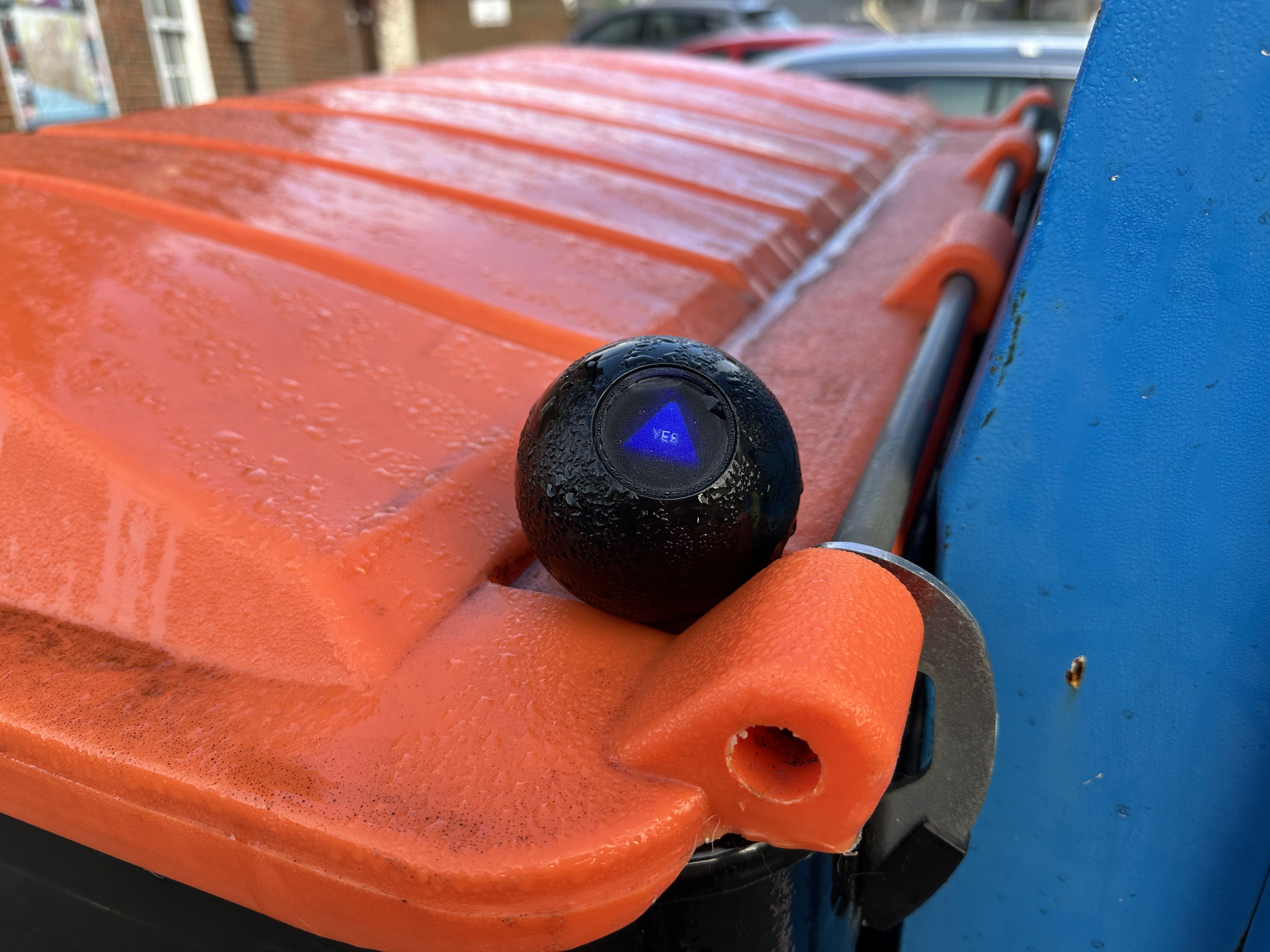 Photo of a magic 8-ball reading 'yes' resting on a bin