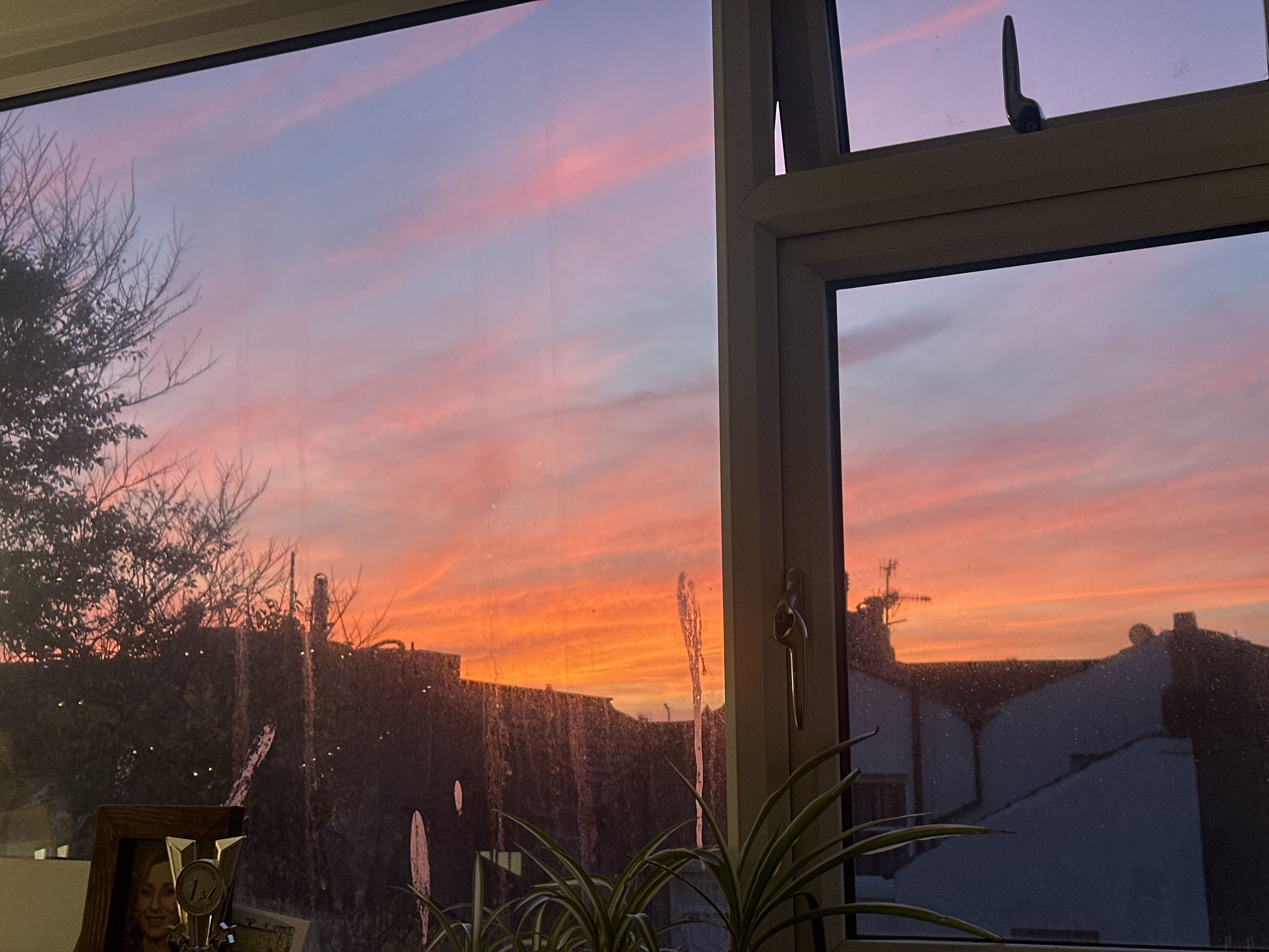 Photo of a sunset out of a idrty window